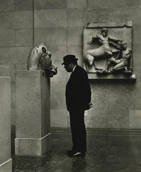 Mies katselee valokuvia British Museumissa Lontoossa 1950-luvulla.