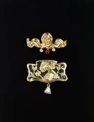 Gustave-Roger Sandozin jugend rintakoru ja jugend rintakorun muotoinen metallisetti, jossa on plique a jour ja helmipisara, kullanvärinen rintakoru ja jalokiviä, n. 1900 (kullanväriset rintakorut, jalokivet)