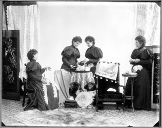 Hannah Maynardin monivalotus - kaksi juomassa teetä, yksi pitelemässä puuvillavyyhtiä ja yksi kerimässä sitä keräksi, noin 1895