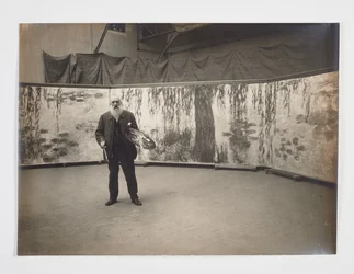 Claude Monet palettillaan Les nymphéas -teoksensa edessä