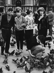 Turistit ruokkimassa kyyhkysiä Piazza San Marcolla, Venetsiassa, noin 1970