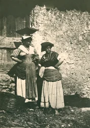 Kaksi maanviljelijää roomalaisella maaseudulla perinteisissä vaatteissa, Italia, n. 1910.
