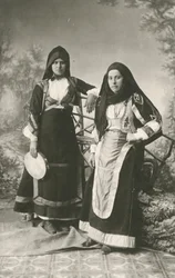 Kaksi naista pukeutuneena perinteisiin vaatteisiin Belvistä ja Aritzosta, Sardiniasta, Italiasta, n. 1910.