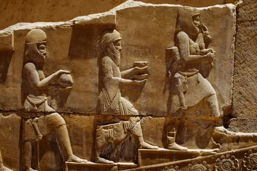 Reliefiveistos, jossa miehet kantavat uhrilahjoja Persepoliksen seinillä. Persepolis, Iran.