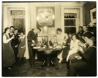 Alice Foote MacDougal viihdyttämässä ryhmää merimiehiä pienessä asunnossaan Old Warissa, Greenwich Villagessa, New Yorkissa, Yhdysvalloissa, n. 1917-18 (gelatiinihopeakuva)