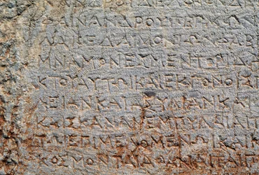 Kirjoitus monikulmisella seinällä, Delphin arkeologisella paikalla (UNESCOn maailmanperintöluettelo)