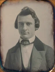 Nuori mies kolmiosaisessa puvussa ja rusetissa, 1850-luku. Tekijät: Josiah Johnson Hawes, Albert Sands Southworth.
