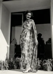 Mallilla on yllään pitkä mekko, jossa kukkakuvio on couture house "Graldi" luoma. Tuotetta täydentää samasta kankaasta valmistettu vaippa. (m/w kuva)