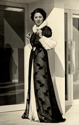 Mallilla on yllään italialaisen couture house "Bernasconin" luoma iltapuku. Esitetty artikkeli koostuu sifonkipäällystakista, jossa on turkisreunattu kaulus ja hihansuut (b/w kuva)