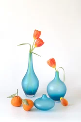 Oranssit tulppaanit ja siniset maljakot