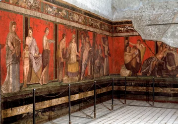 Vihkiminen Dionysoksen palvontaan: nuori mies johdatetaan palvontaan ja lukee rituaalia samalla kun pieni poika tuo uhrilahjan. 1. vuosisata eKr. Fresko Villa dei Misteristä Pompejissa, Italiassa