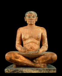 Egyptiläinen muinaisesine: "Kyykistyvä kirjuri". Kalkkikivestä, alabasterista ja vuorikristallista valmistettu patsas. Peräisin Sakkarasta (Saqqara) (noin 2620 - 2350 eaa.). 4. tai 5. dynastia. Korkeus 0,537 m, Musée du Louvre, Pariisi