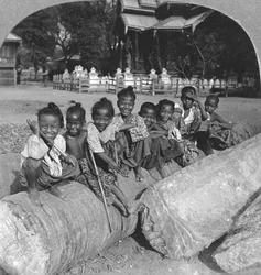 Burmalaiset lapset istuvat palmulla, Burma, 1908