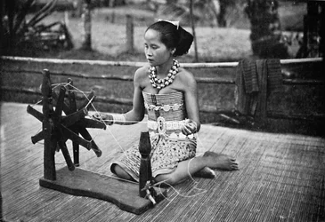 Dayak-tyttö pyörivän pyörän ääressä, 1902