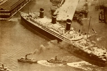 Ilmakuva Leviathanista, jota pienet hinaajat hinataan laituriinsa New Yorkissa, vuonna 1930