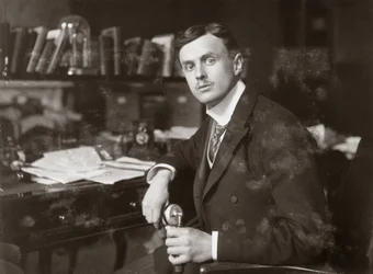 C S Rolls istuu pöytänsä ääressä, n. 1902