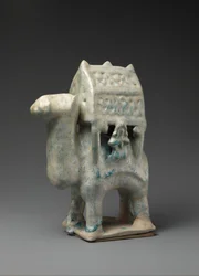 Kamelin muotoinen hahmo, joka kantaa palankiinia ja kahta ratsastajaa, 1200-1200-luvun alku.