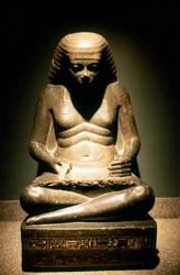 Graniittipatsas istuvasta muinaisesta egyptiläisestä kirjurista, Karnakista, 1718. dynastia, n. 1500 eaa.
