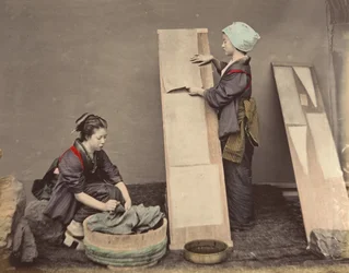 [Kaksi japanilaista naista poseeraa pyykin kanssa], 1870-luku.