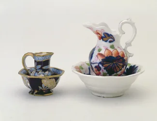 Vasemmalla: Crown Staffordshire -kannu ja allas ja oikealla: Walesin kaiteet kannu ja allas (keraaminen)