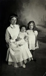 "Sairaanhoitaja" poseeraa lasten kanssa 1920-luvulla.