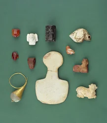Kokoelma itäisen Välimeren esineitä, mukaan lukien sumerilainen korppikotka-amuletti, akkadilainen käärmehylje ja Mesopotamian karneoli-sammakko, vuosilta 3300-2000 eaa.