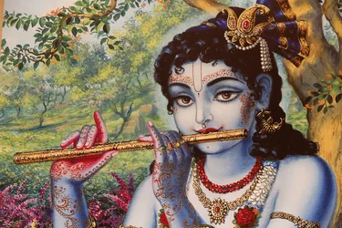 Maalaus hindujumala Krishnasta soittamassa huilua ulkona. Intia