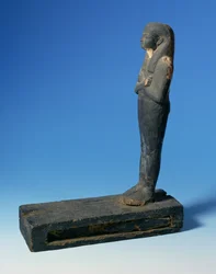 Ptah-Sokar-Osiris-hahmo, kolmiosainen peruukki ja ristissä olevat kädet suorakaiteen muotoisella jalustalla, jossa on osa papyrusta (katso 83304), egyptiläinen, 21.–22. dynastia, noin 900 eKr. (puuta) (katso yksityiskohdat 83306)