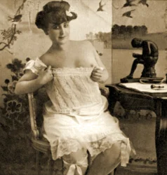 Nuori nainen näyttämässä pitsipukua, n. 1900