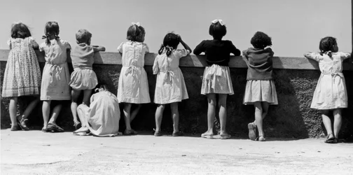 Ryhmä lapsia nojaamassa kaidetta vasten, Italia, n.1960 (gelatiinihopeakuvio).