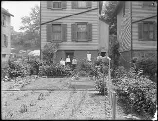 Perhe poseeraa takapihansa kasvimaan vieressä, Inwood, New York, noin 1910