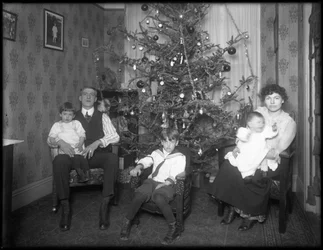 Epävirallinen ryhmäkuva tuntemattomasta perheestä heidän asunnossaan istumassa joulukuusen edessä, New York City, n. 1915-1616