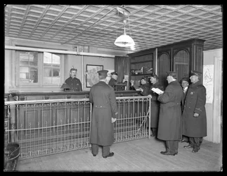 Tuntemattoman poliisiaseman sisäpiha, jossa on virkailijat ja vastaanotto, n. 1913-14
